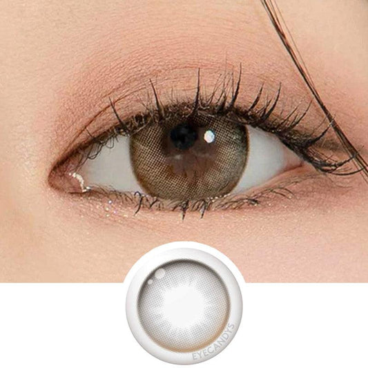 Macro shot of an eye wearing the DooNoon Glam 1-Day Grey (10pk) prescription colour contact lens, showing the multi-colored detail and natural effect on dark brown eyes, with clean eye makeup. At the bottom is the pattern of the colored lens design, showing the dotted detail and pigmentation.