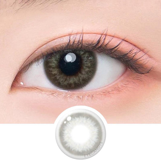 Macro shot of an eye wearing the DooNoon Rona 1-Day Grey (10pk) prescription colour contact lens, showing the multi-colored detail and natural effect on dark brown eyes, with clean eye makeup. At the bottom is the pattern of the colored lens design, showing the dotted detail and pigmentation.